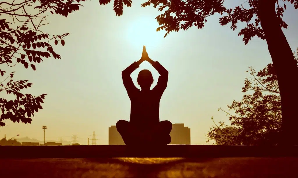 Silhouette d’une personne en position de yoga au coucher du soleil