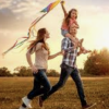 Les parents et enfant courant dans un champ, illustrant le plaisir de bouger et la joie de vivre au quotidien