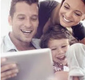 Famille réunie autour d’une tablette, représentant un soutien au quotidien et une relation de confiance