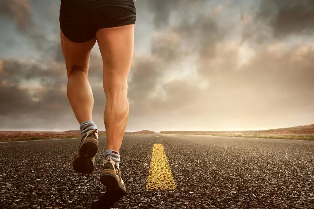 Une personne en tenue de sport court sur une route, symbolisant l’importance de l’activité physique pour mieux vivre avec le diabète.