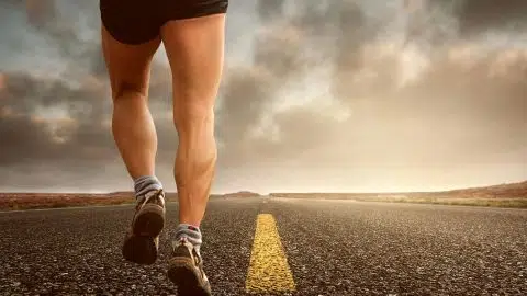 Une personne en tenue de sport court sur une route, symbolisant l’importance de l’activité physique pour mieux vivre avec le diabète.