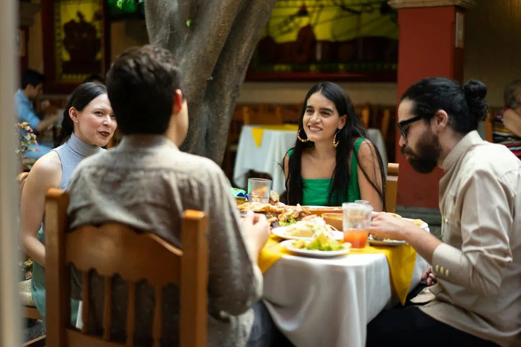 Groupe d’amis partageant un repas au restaurant dans une ambiance détendue, illustrant comment gérer le diabète lors de sorties